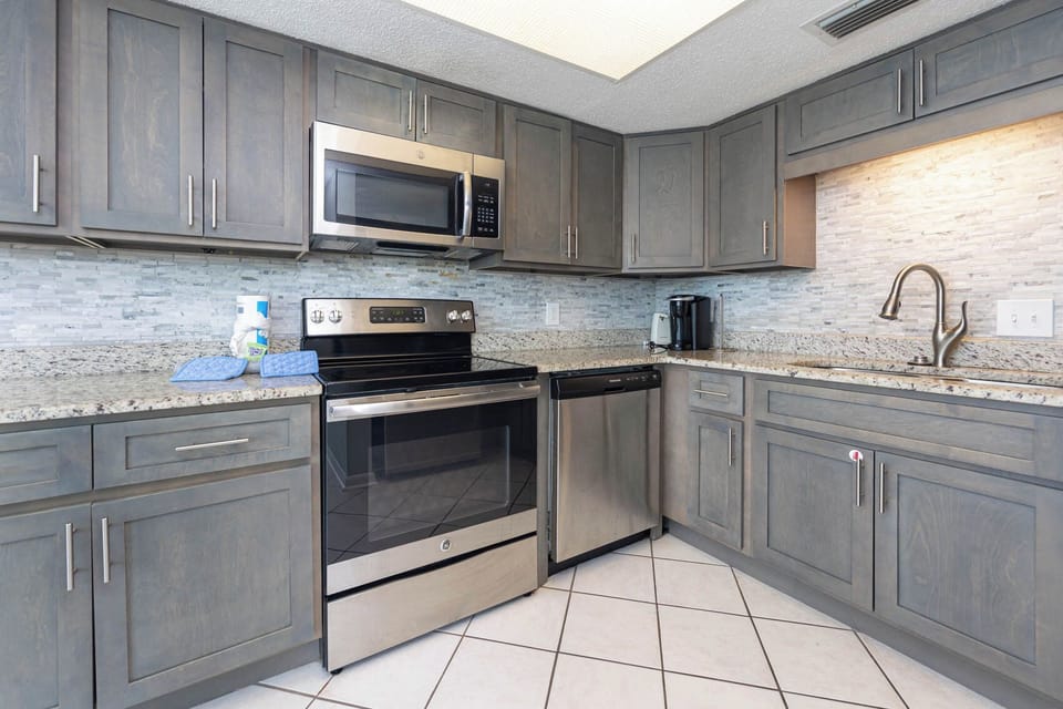 This modern kitchen features stainless appliances, granite countertops, and a Keurig coffee maker for your morning brew