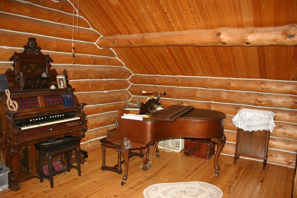 grand piano and manual pipe organ in loft