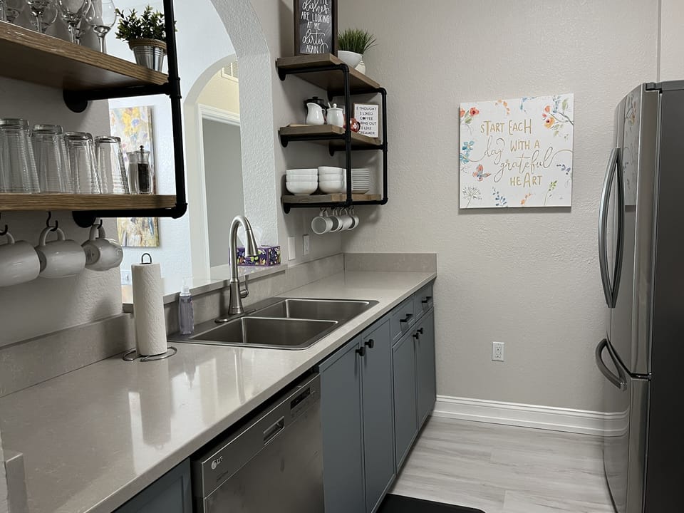 The kitchen is fully stocked with dishes, appliances and cookware.