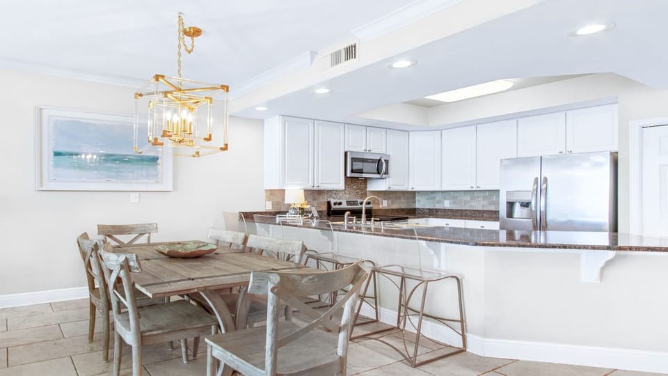 Modern kitchen with granite, acrylic barstools & dining table—seats 10 total