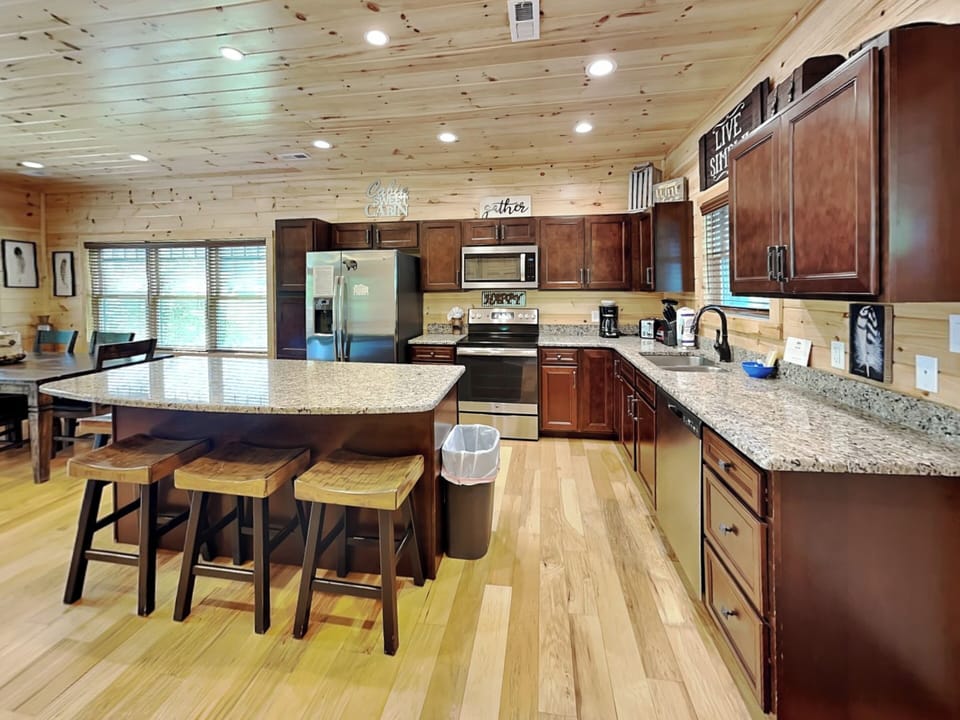 Fully Equipped Kitchen with Stainless Steel Appliances and Breakfast Bar Seating for Four