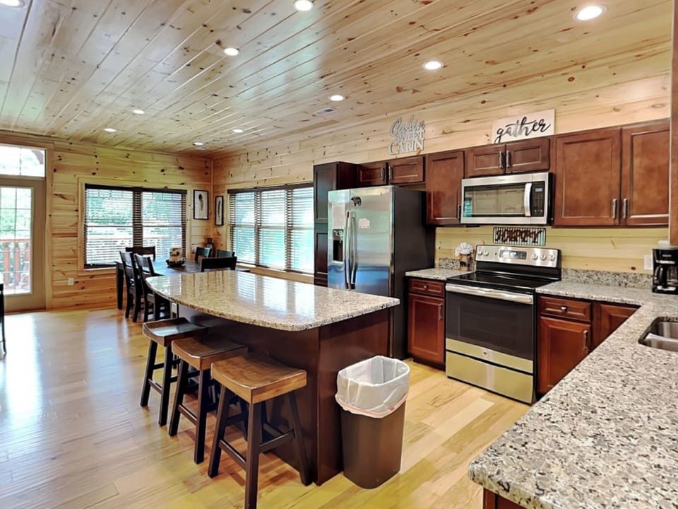 Fully Equipped Kitchen with Stainless Steel Appliances and Breakfast Bar Seating for Four
