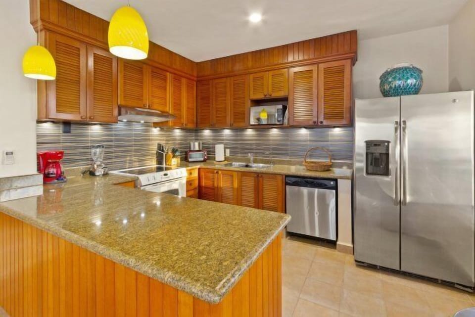 Fully equipped kitchen with utensils, pots, pans, glassware, cookware, microwave, coffee maker, stove with oven, refrigerator and freezer