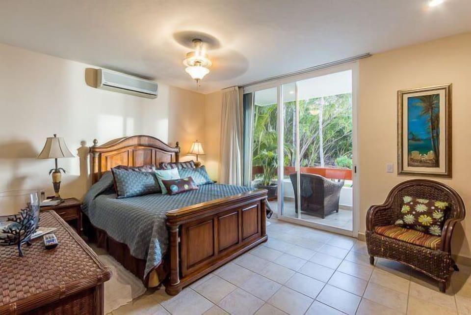 Bedroom 1 has a king size bed with plush bedding, a 46 inch TV, and a private ocean view patio