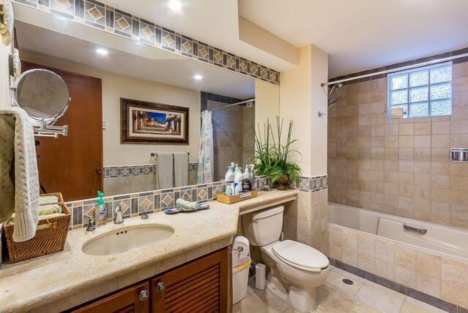 Hallway Bathroom 1 has a tub and shower and lots of extra toiletries