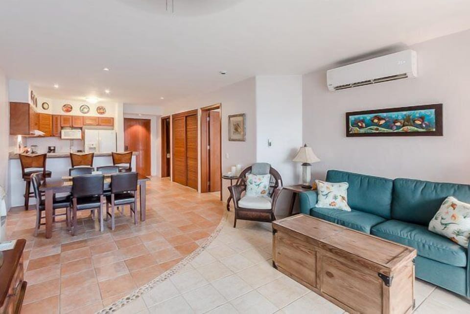 The living room has a TV, lots of seating and is adjacent to the dining room and kitchen
