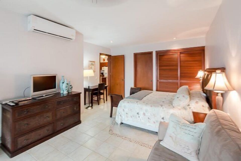 The bedroom has a king size bed, a separate sitting area, a TV, and opens up to the terracae
