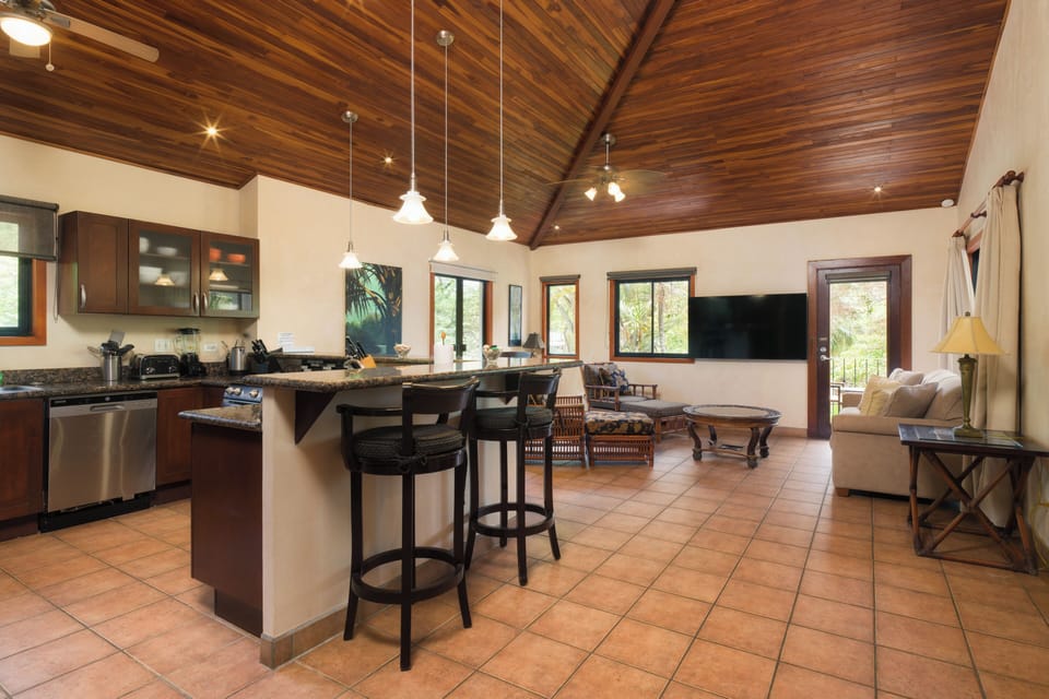 View from kitchen to great room. High vaulted teak ceilings