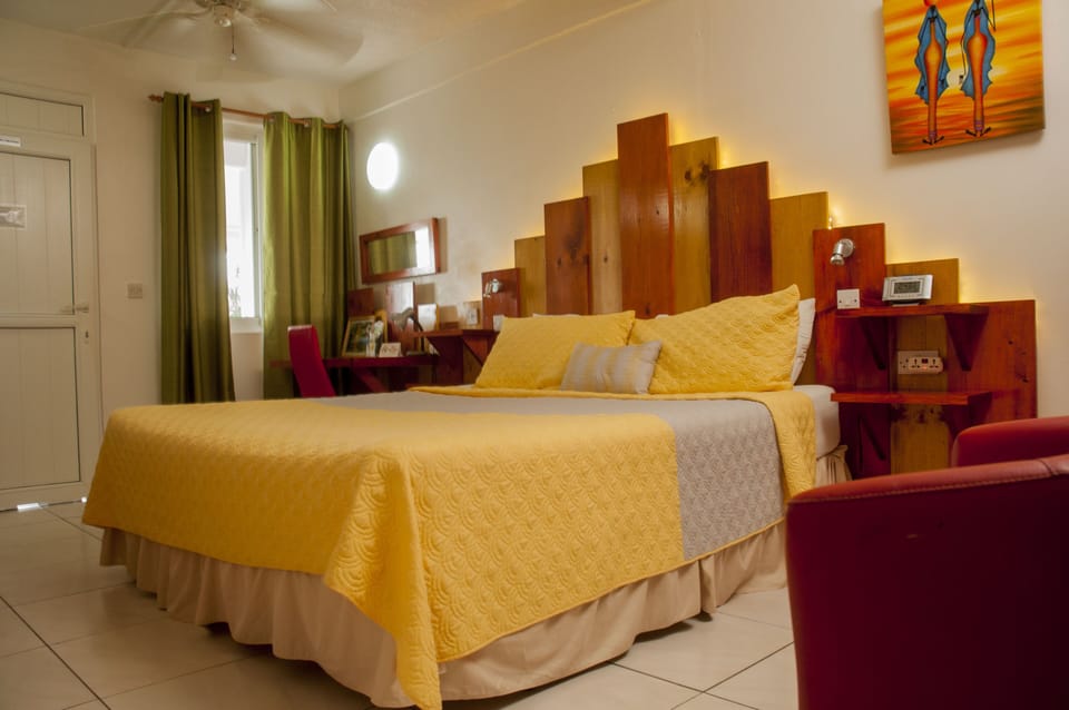 Interior of a Superior Room with a King Bed, table chair and bed lamp
