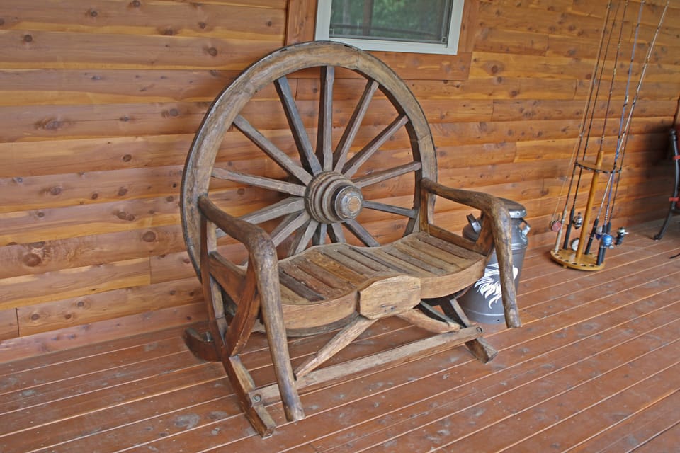 Relax on the enclosedback porch on our antique wagonwheel bench!
