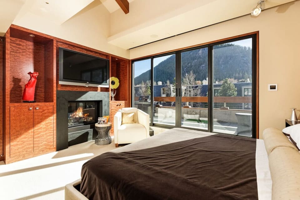Primary Bedroom with King Bed, Gas Fireplace, Balcony Access & Views of Aspen Mtn
