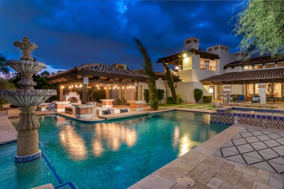 Enjoy this spacious 11-bedroom home featuring a pool, stone fountain, and covered outdoor kitchen. The outdoor area offers a peaceful setting with ambient lighting, perfect for relaxing or spending time with your group.