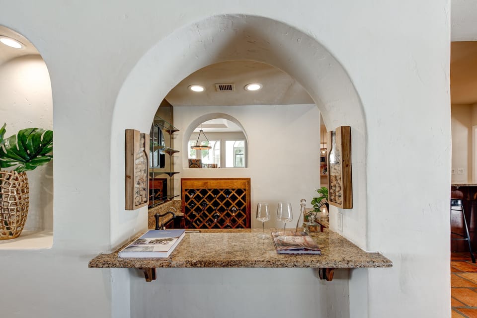 Unwind in style at the 11 BR Valley Vista Mansion's built-in wine bar featuring arched architecture, granite counter, and custom wine rack—perfect for entertaining or an intimate evening in Scottsdale luxury.