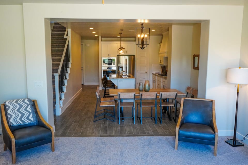 Living Room View Into Dining Table & Kitchen - The living room is designed as an open floor plan and is a great gathering place for meals, games, or watching TV during your stay.