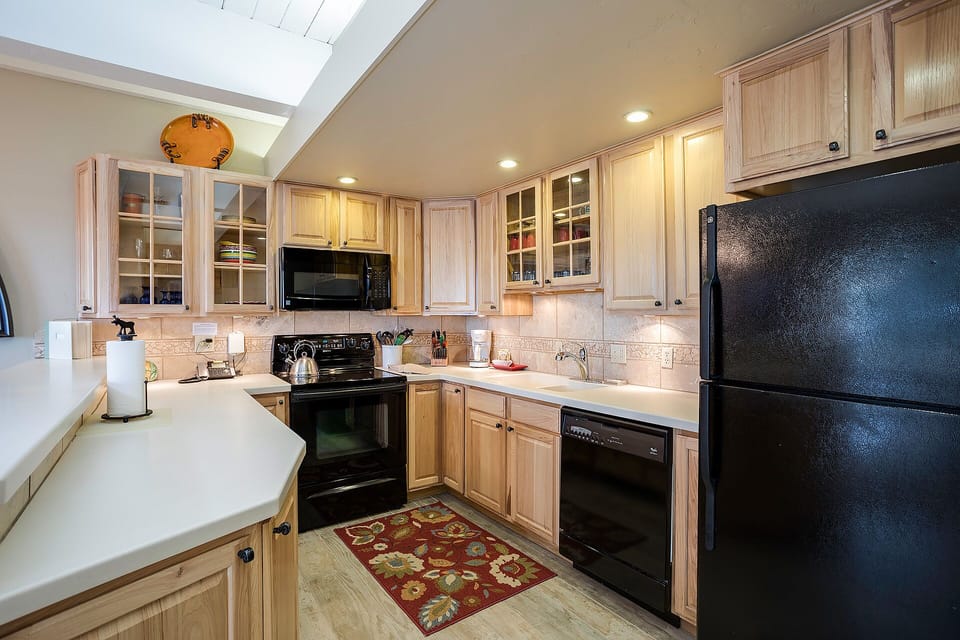 Cook your favorite meals in this fully equipped kitchen with warm wood cabinetry, modern appliances, and plenty of counter space for preparation.