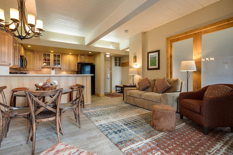 Settle into your spacious open-plan retreat, where rich wood beams and warm lighting create the perfect mountain getaway atmosphere.