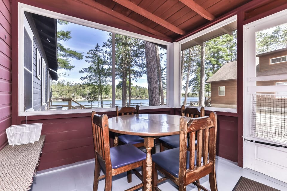 Gather around the table in a screened in porch with a beautiful view at the lake.