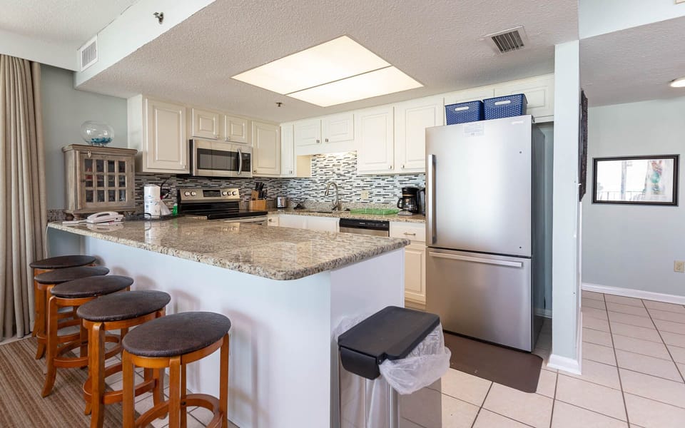 This modern kitchen features stainless appliances, granite countertops, and a cozy breakfast bar for casual dining