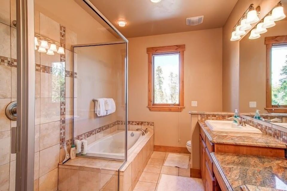 Master Bath with double-sink vanity, glass shower and jetted tub.