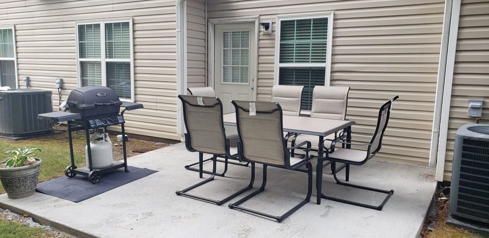 Back patio, table, and gas grill.