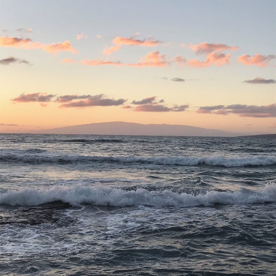 Surf at high tide and Maui in the background.