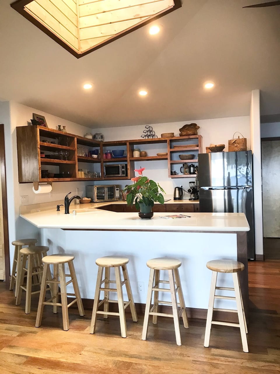 Open kitchen with custom built in Koa wood shelving