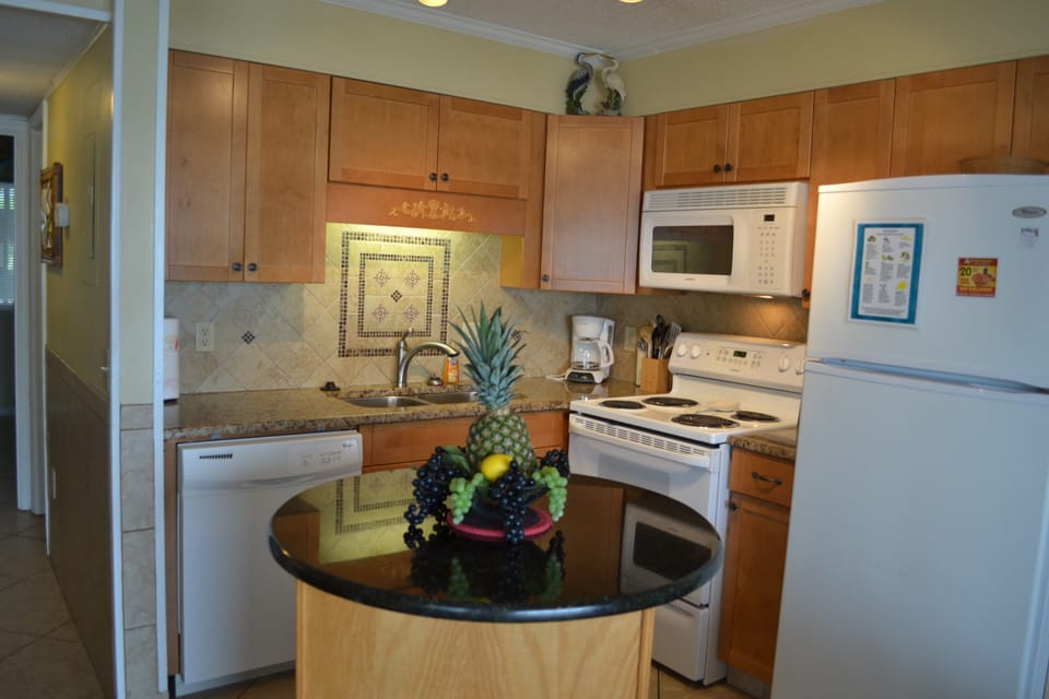 Kitchen with dishwasher, stove, microhood, and refirgerator.  