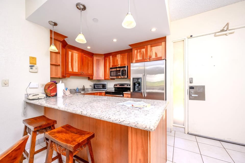 Inviting granite breakfast bar and full kitchen with stainless appliances.

