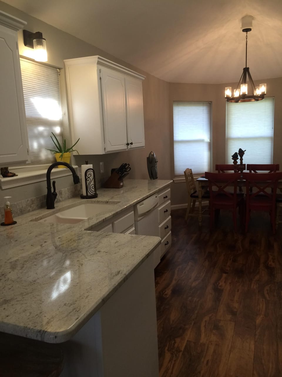Rustic lighting and a bay window make for homey mealtimes.