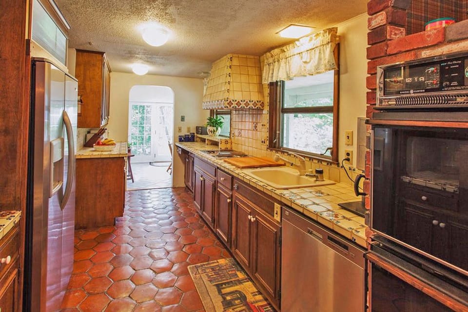 Kitchen w/ double wall ovens, deep sink, and cooktop is stocked with essentials