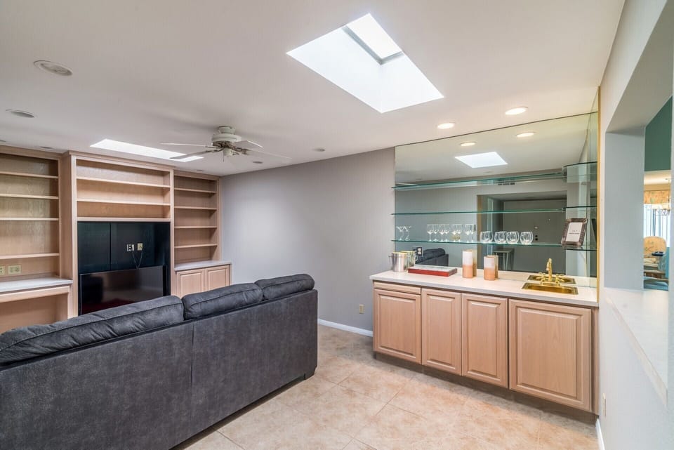 Living room area with pull out queen bed, desk, tv, and a bar