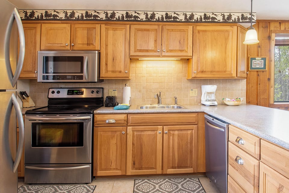You'll love preparing meals in this fully equipped kitchen with warm wood cabinets, stainless steel appliances, and ample counter space.