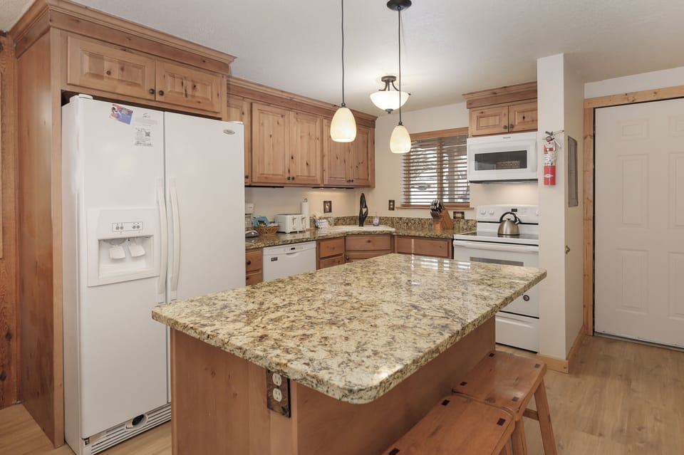Your spacious kitchen invites culinary adventures with warm wood cabinetry, granite counters, and modern appliances—perfect for creating memorable meals.