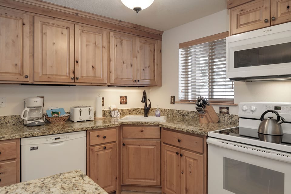 Your fully equipped kitchen features warm wood cabinets, granite counters, and everything you need to create memorable meals during your stay.