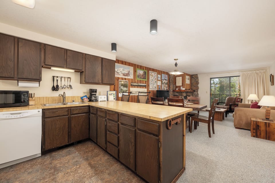 Unwind in your cozy mountain retreat where rustic wood cabinets and stone fireplace create warmth for memorable evenings together.