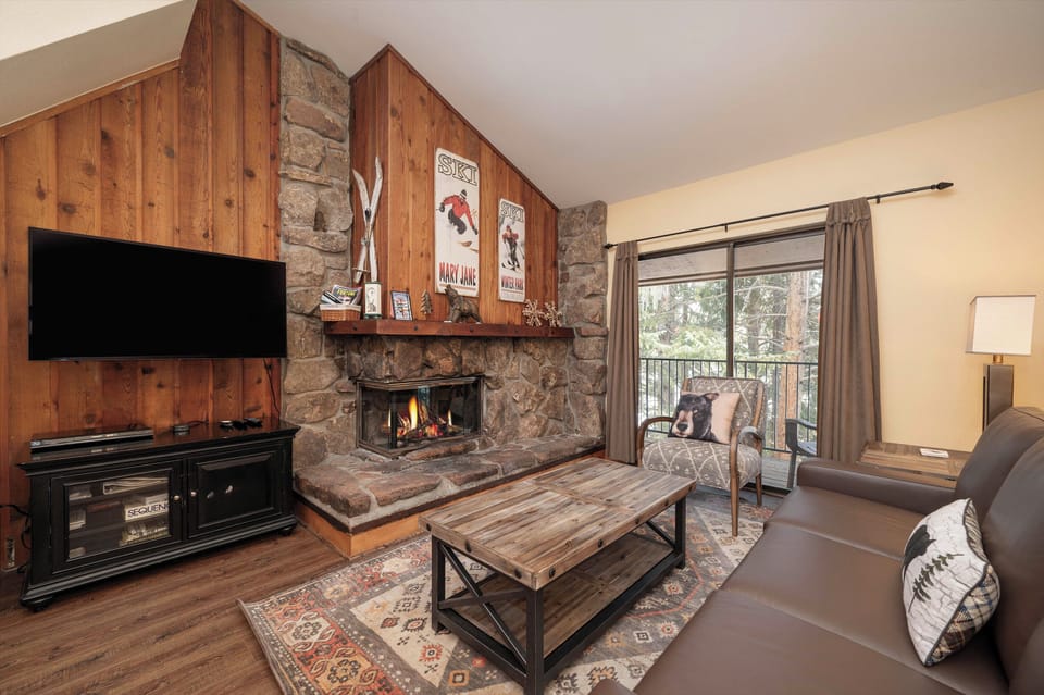 Cozy up by your crackling stone fireplace while enjoying mountain views from your private balcony in this rustic alpine retreat.