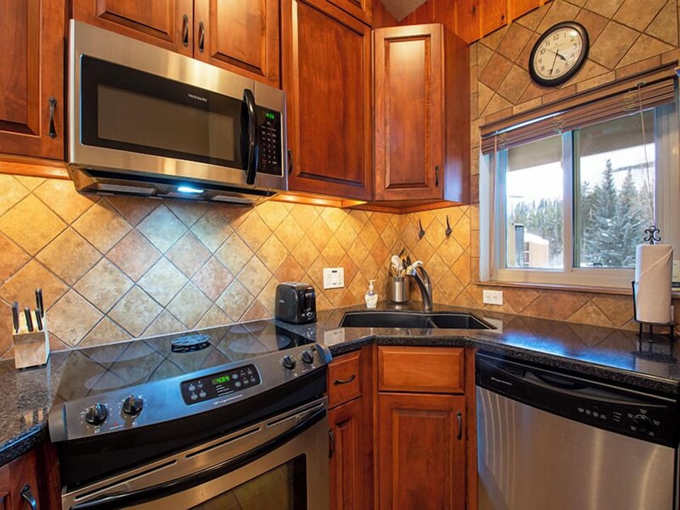 Your fully equipped kitchen features granite counters, stainless appliances, and warm wood cabinets—perfect for preparing meals during your stay.