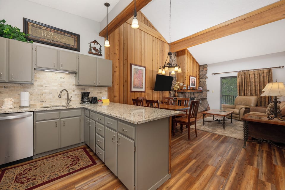 Step into your cozy mountain retreat where rustic charm meets modern comfort—granite counters and vaulted ceilings create perfect gathering spaces.