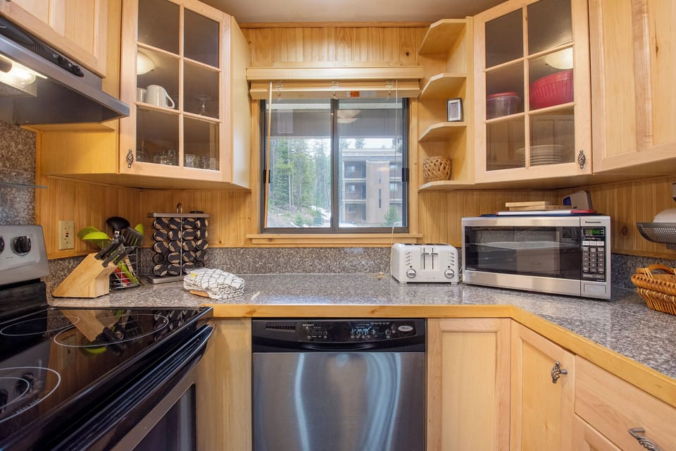 Your fully equipped kitchen features warm wood cabinets, granite counters, and stainless steel appliances—perfect for preparing memorable meals during your stay.