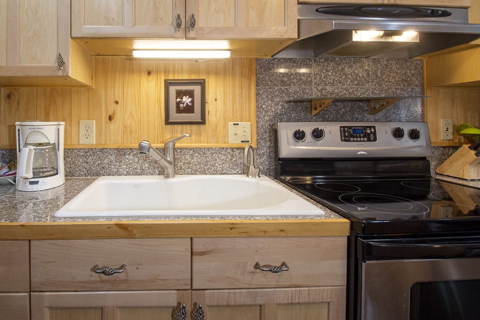 Your cozy kitchen features warm wood cabinets, granite counters, and everything you need to prepare memorable meals during your stay.