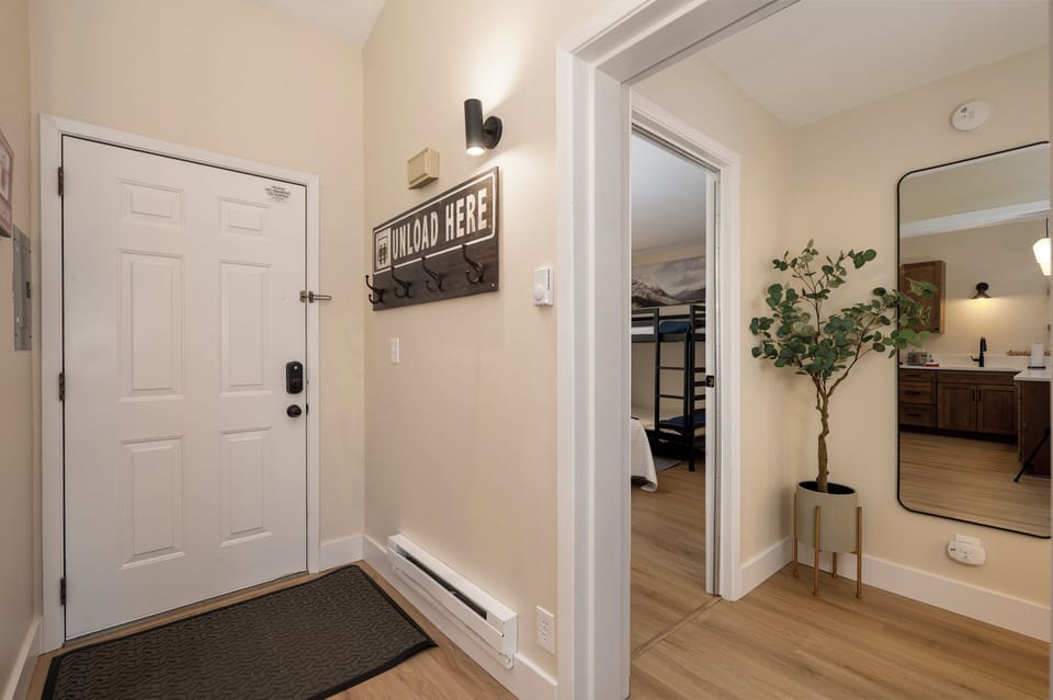 Step into your welcoming entryway where thoughtful touches like the charming coat hooks and warm lighting create an instant feeling of home.