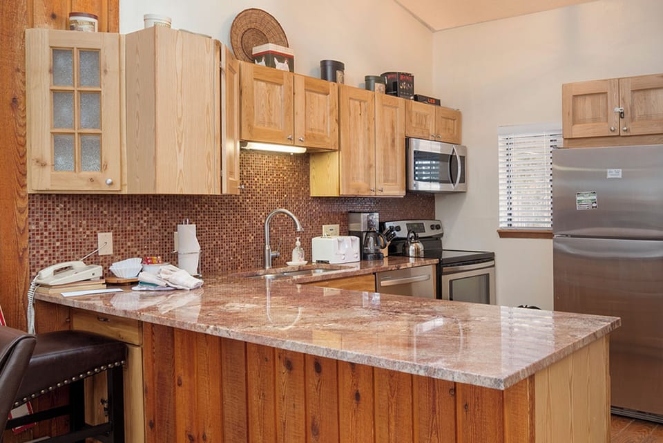 Your fully equipped kitchen features granite counters, rich wood cabinets, and stainless appliances for memorable home-cooked meals.