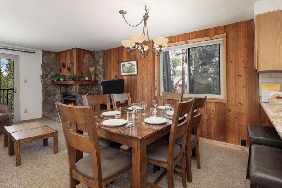 Gather around your warm dining table while the stone fireplace crackles, creating perfect moments for memorable meals together.