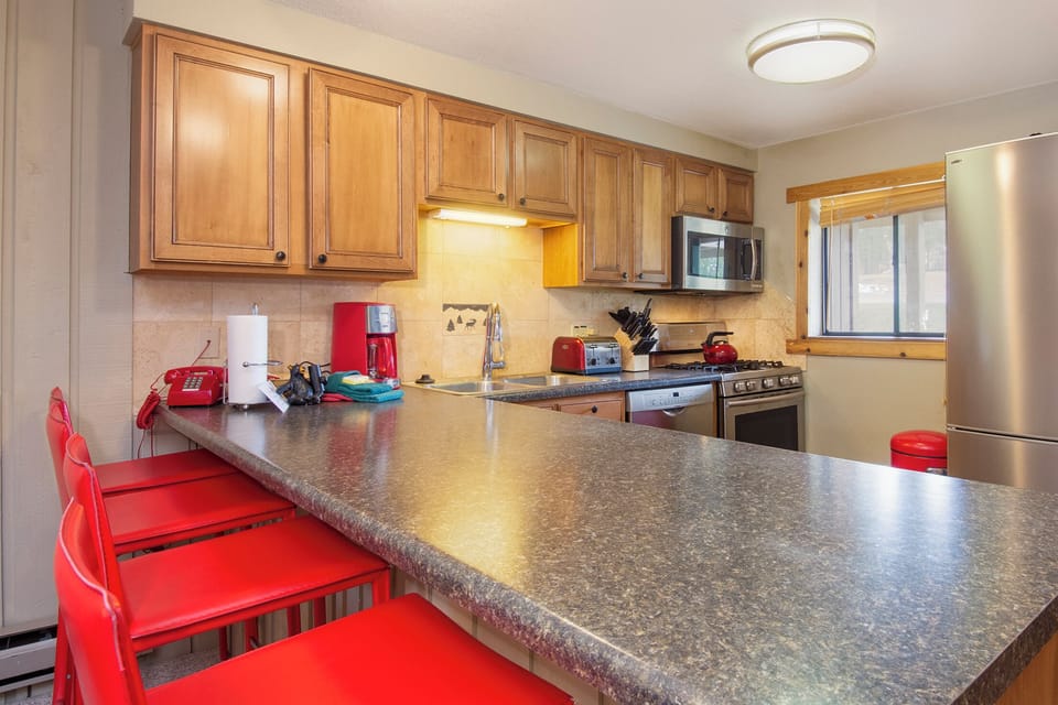 Your fully equipped kitchen features granite counters, stainless appliances, and a breakfast bar where you can enjoy morning coffee.