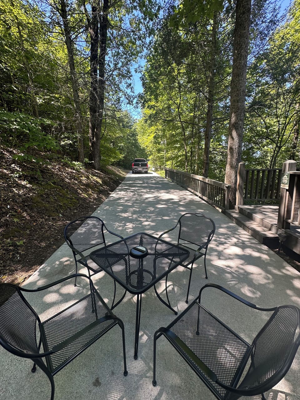 Front porch area with patio table and chairs and a charcoal grill~