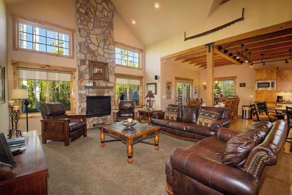 Sink into rich leather seating by your crackling stone fireplace, where soaring ceilings and warm wood create your perfect mountain retreat.