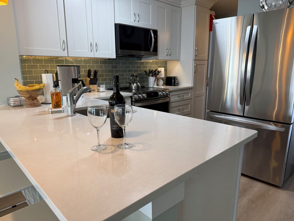 New kitchen with to the ceiling cabinetry, quartz counters, new stainless steel appliances include oven with built in air fryer.  Both Kuerig and old school coffee maker.  Crockpot, and spices for cooking .