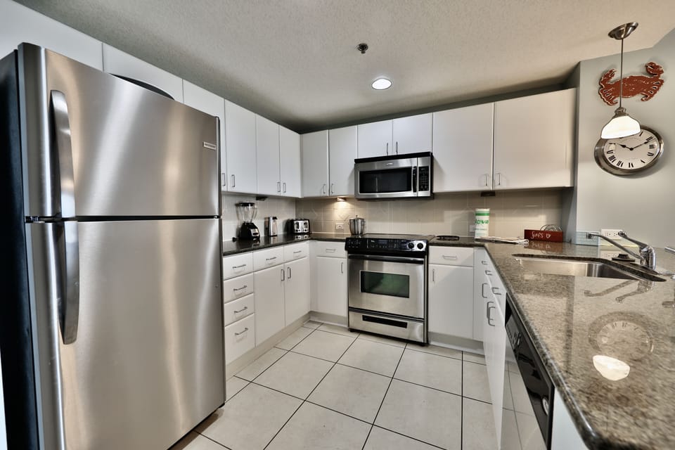 Fully stocked kitchen with stainless steel appliances.