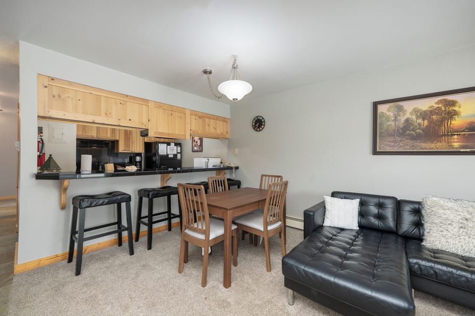 You'll love this open living space where cozy leather seating meets your full kitchen with breakfast bar—perfect for meals and relaxation.