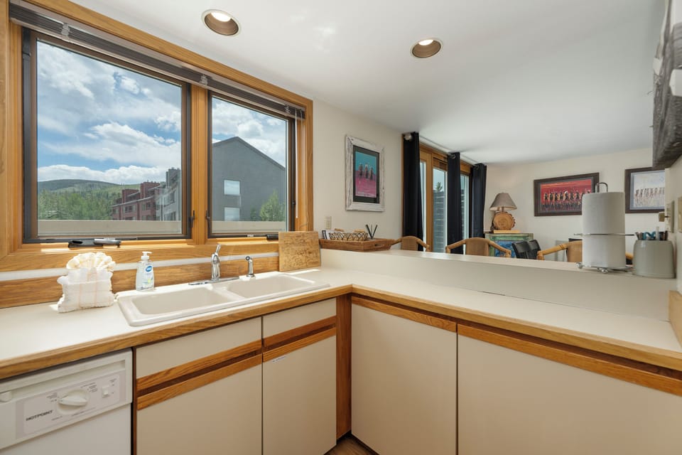 Cook with mountain views in your fully equipped kitchen, where natural light streams through windows overlooking the scenic landscape.